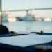 Yacht compliance readiness documents on a navy table overlooking a marina