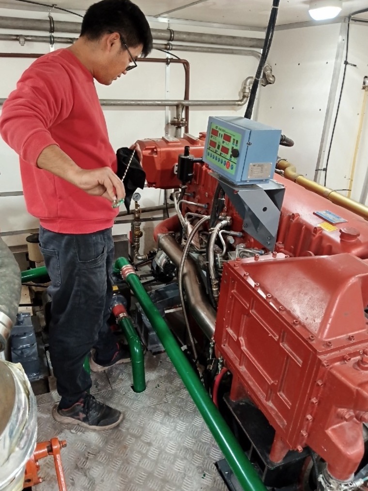 Technician servicing a red marine engine