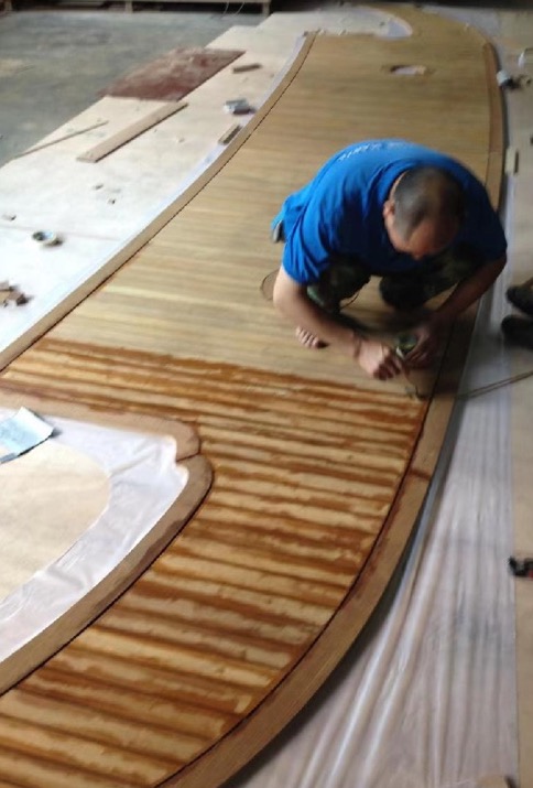 Craftsman working on a teak deck at the workbench