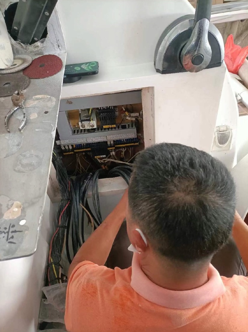 Internal yacht console wiring with a technician at work